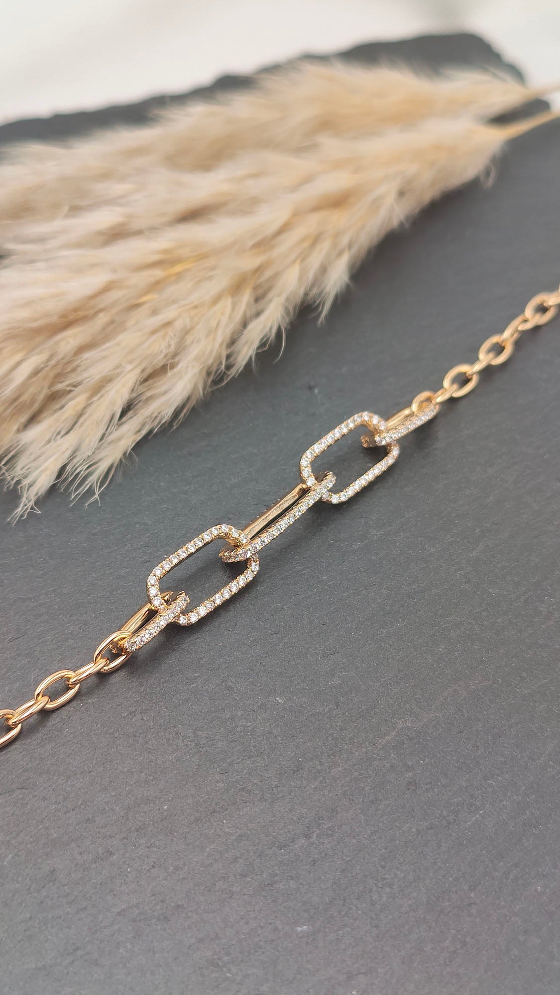 Cecilia Linked Pavé Bracelet featuring interlocking gold-tone links with pavé crystal accents, displayed on a slate background.