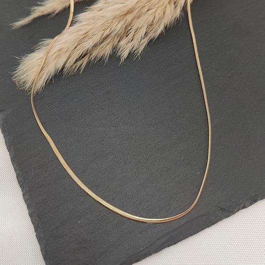 Lucinda Sleek Snake Chain Necklace featuring a smooth, flowing design with a polished finish, perfect for layering or wearing alone.