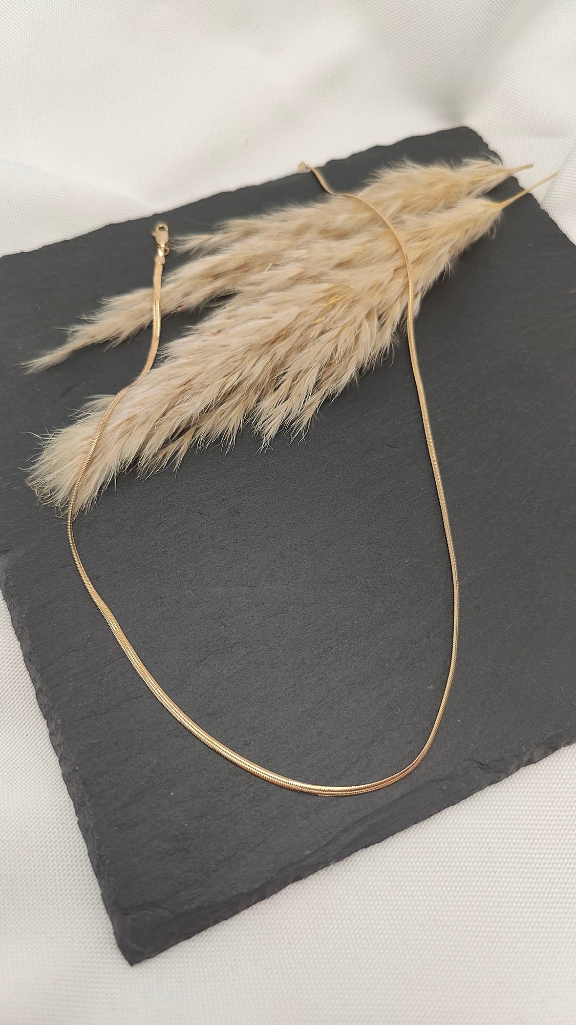 Lucinda Sleek Snake Chain Necklace featuring a smooth, flowing design with a polished finish, perfect for layering or wearing alone.