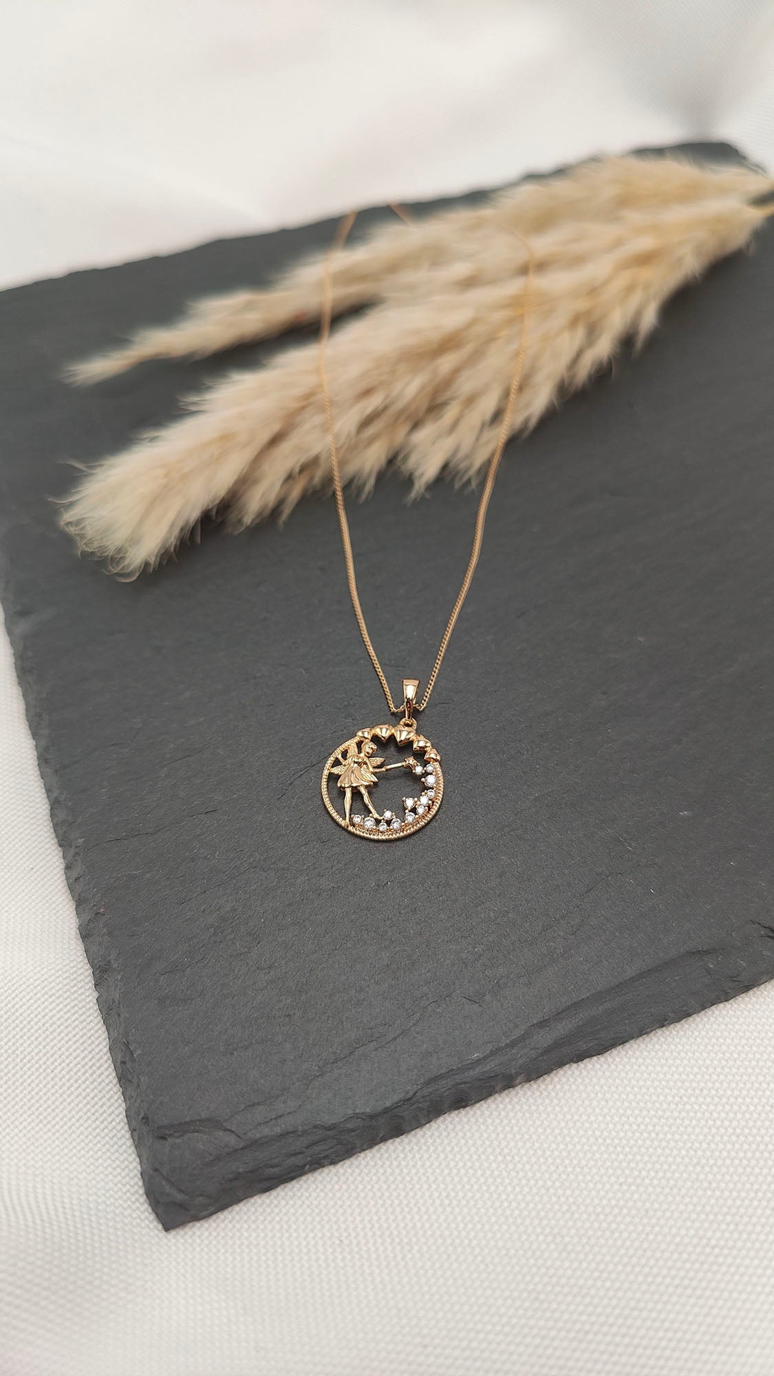 Luna Fairy Pendant Necklace featuring a fairy within a circular pendant adorned with sparkling gemstones.