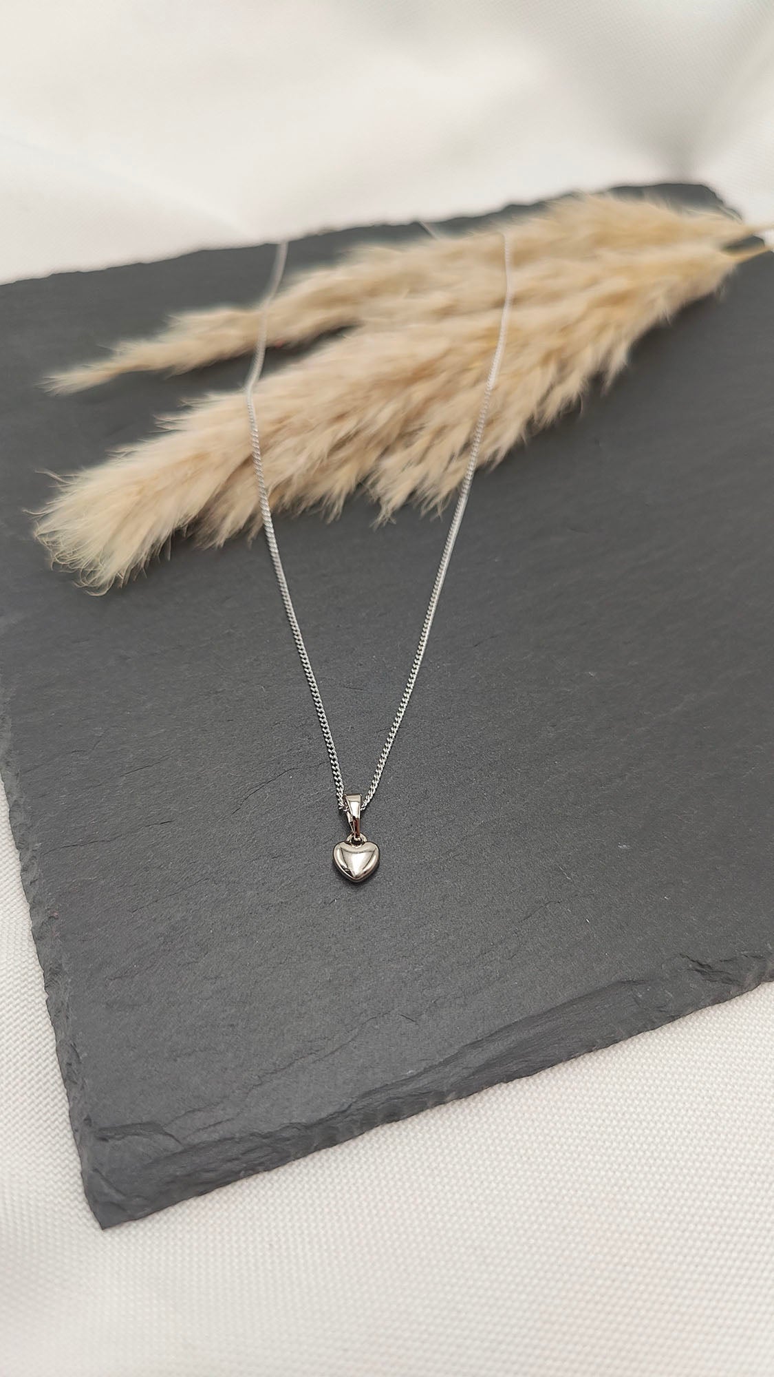 Clara Petite Heart Necklace featuring a silver-colored polished heart pendant on a fine chain.